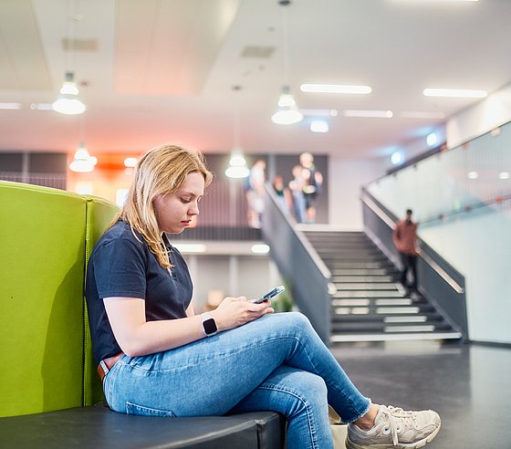 Studentin im Foyer von Gebäude K auf dem Campus Grifflenberg der Bergischen Universität Wuppertal
